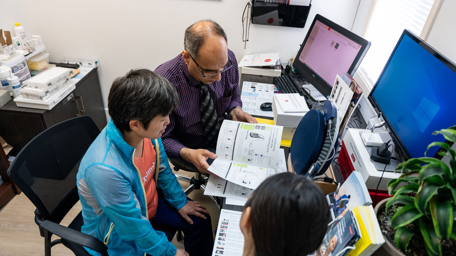 Provider going through hearing aid styles with patient