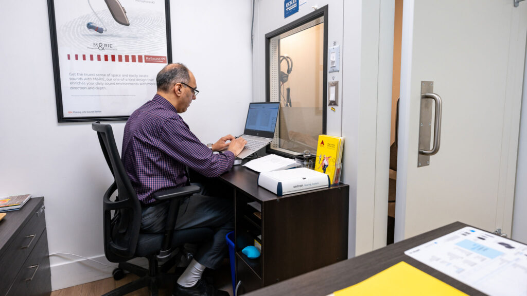 Hearing provider performing a hearing test in sound booth